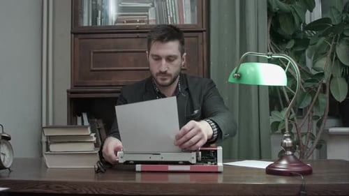 Focused Man Typing on Vintage Typewriter Indoors