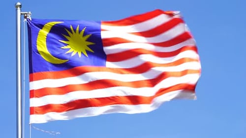 Malaysian Flag Waving in the Wind on Sunny Day