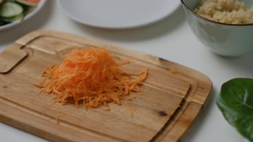 Close-up of Female hands grate carrots on white table. Top view Cooking Salad.