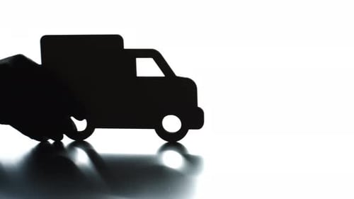 Hand places truck silhouette for express delivery
