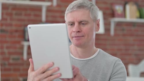 Mature Man Using Tablet Device at Home