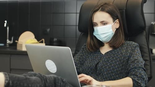 Woman Working on Laptop Wearing Face Mask