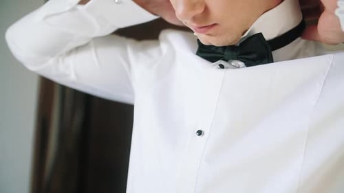Man Adjusting Bow Tie Before a Wedding