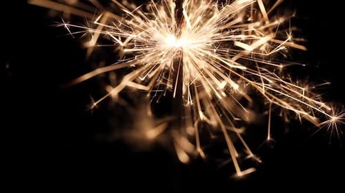 Bright Sparkler Emitting Golden Sparks on Dark Background