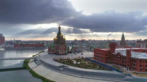Dramatic sky over city's promenade. Orthodox cathedral is illuminated by the sun