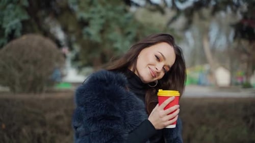 Stylish Woman with Coffee in Urban Park