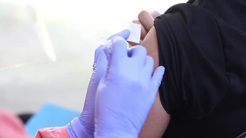 Close-up video of a man's arm being injected with the corona virus vaccine
