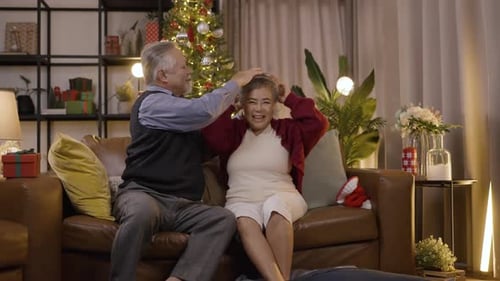 Cheerful Senior Couple Celebrating Christmas Together at Home