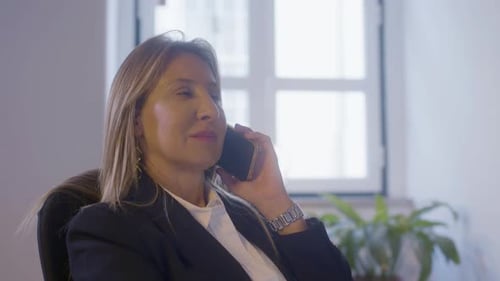 Professional Woman Talking on Cell Phone in Office