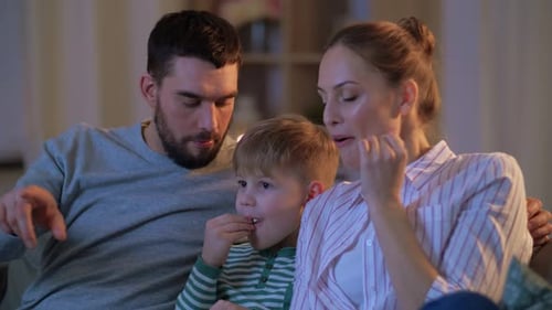 Family Together Watching TV at Home Eating Popcorn