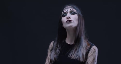 Woman with Dark Makeup Posing on Black Background