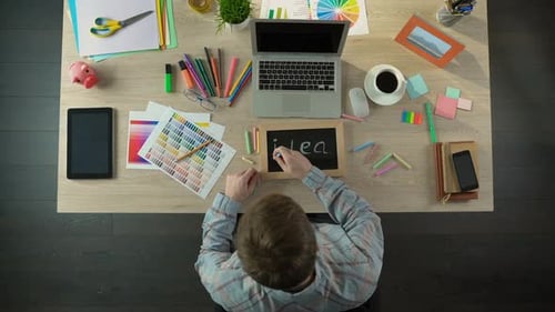 Excited Man Writing Idea on Blackboard, Full of Inspiration to Begin Working Day