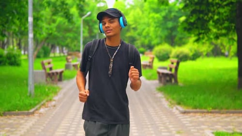 Person Dancing and Walking Through a Green Park