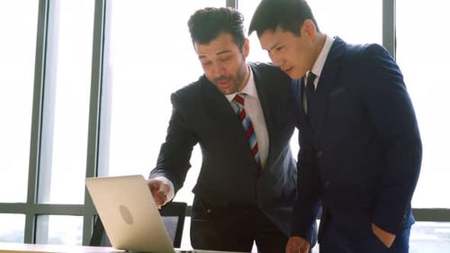 Two Business People Talk Project Strategy at Office