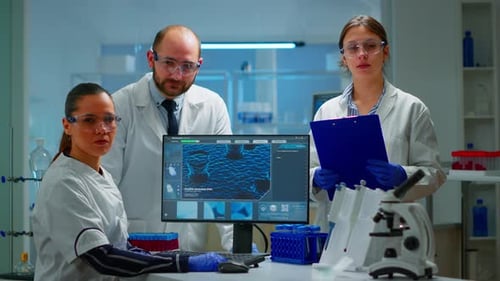 Équipe de scientifiques assis dans un laboratoire regardant la caméra