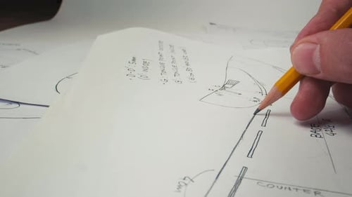 Gros plan sur les mains de l'homme dessinant des lignes sur papier. Architecte à l'aide d'un crayon Faire des plans sur papier