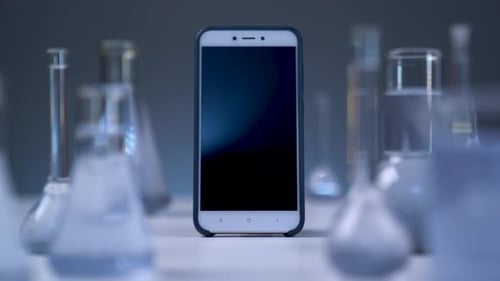Smartphone Amidst Science Lab Glassware