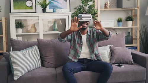 Man Immersed in Virtual Reality on Couch