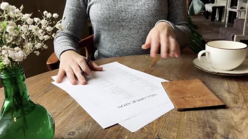 Woman Completes Visa Application at Cafe Table