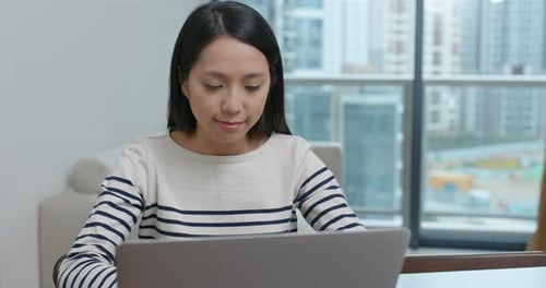 Woman Using Laptop in Modern Urban Apartment