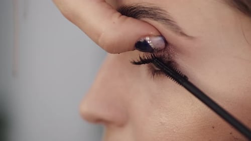 Nahaufnahme des Prozesses des Färbens der Wimpern des Kunden im Schönheitssalon