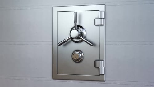 Mechanical dial combination safe full of gold bars mounted on a white wall.