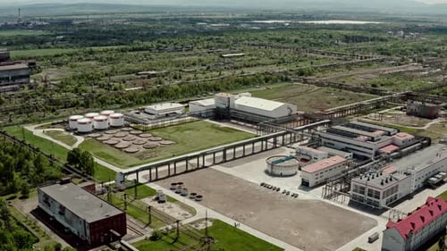 Vue aérienne panoramique sur une raffinerie de pétrole ou une usine chimique avec de nombreux réservoirs de stockage et pipelines