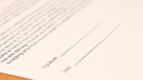 Hand Signing Document with Black Pen Close Up