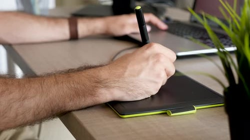 Man Using Graphics Tablet With Stylus Pen