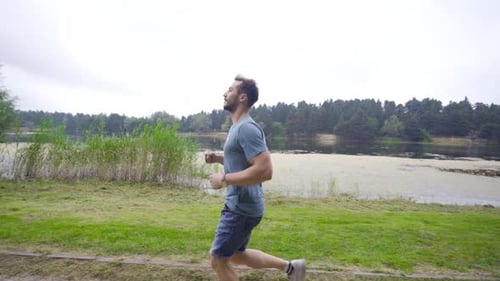 The jogger man jogging in the nature field.