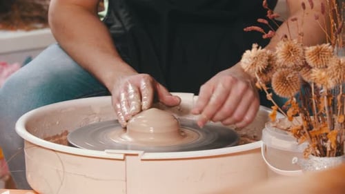 Poterie - Un maître potier travaille avec de l'argile sur un tour de potier dans un atelier