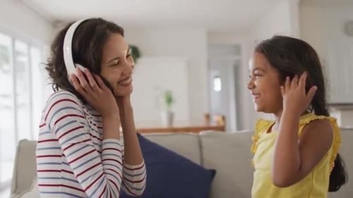 Woman and Child Listen to Music Together at Home