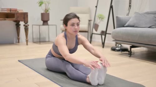 Woman Stretching Legs on Yoga Mat at Home