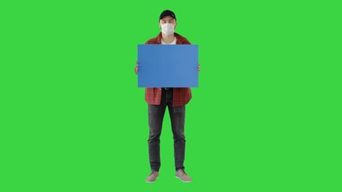 Young Man in Casual Wear Holding Copy Space Board on a Green Screen, Chroma Key
