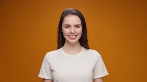 Woman Smiling Portrait Against Orange Background