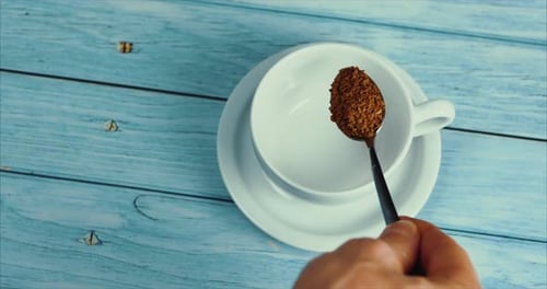 Pouring Instant Coffee Granules into a Cup