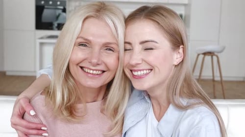 Blonde woman and mature woman smiling indoors