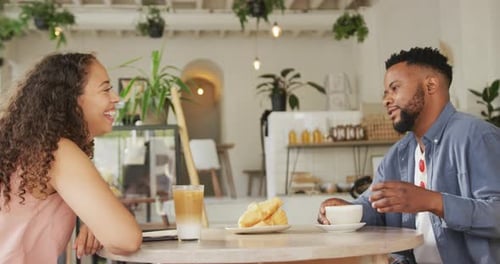 Happy diverse couple spending time together at cafe, drinking coffee and talking