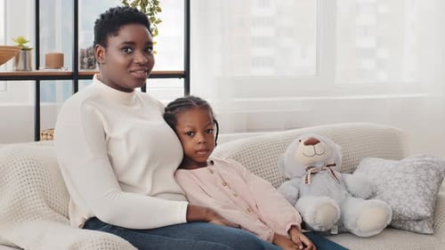 Mother and Daughter Resting Comfortably Together on Couch