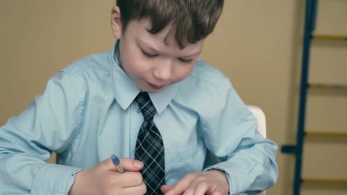 Student Writing Attentively at School Classroom Desk