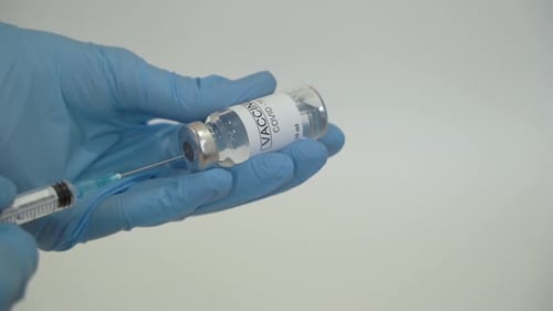Der Arzt zieht den Coronavirus-Impfstoff in eine Spritze.