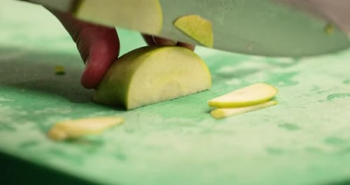 Chef Slicing Fresh Green Apple On The Chopping Board In The Restaurant Kitchen - slow motion