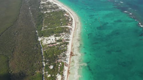 Estabeleça a vista superior em câmera lenta de uma praia tropical vazia com oceano claro em Tulum, México, com um