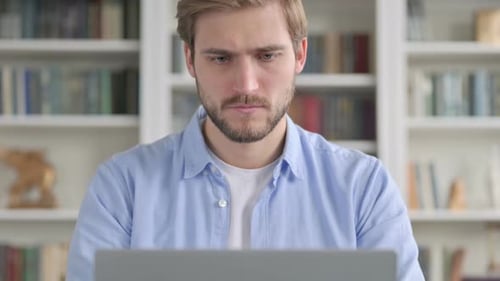 Man Working on Laptop Looks Frustrated