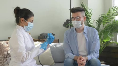 Doctor Examining Patient with Stethoscope During Home Visit