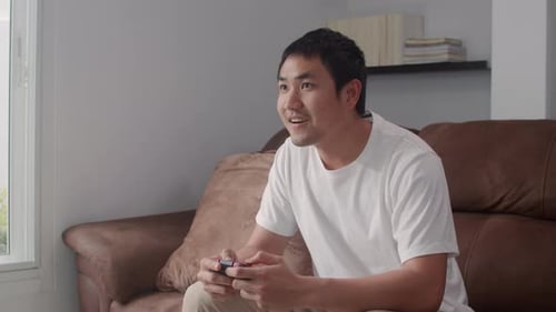 Enthusiastic Young Man Playing Video Game at Home