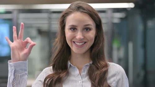 Woman Shows OK Sign in the Office