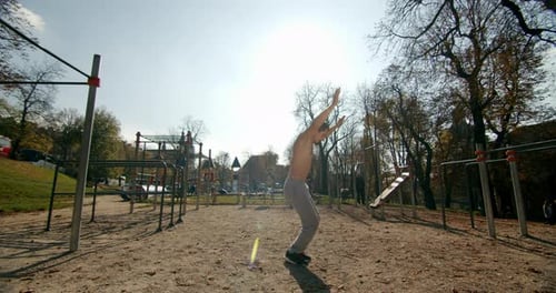 Un homme fait un burpee sur le terrain de sport par beau temps