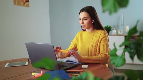 Woman working on laptop at home at table