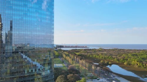 Vista ascendente del pedestal de un edificio moderno en Puerto Madero, Buenos Aires, que revela el río Pla